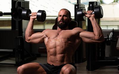 A lifter pressing dumbbells overhead