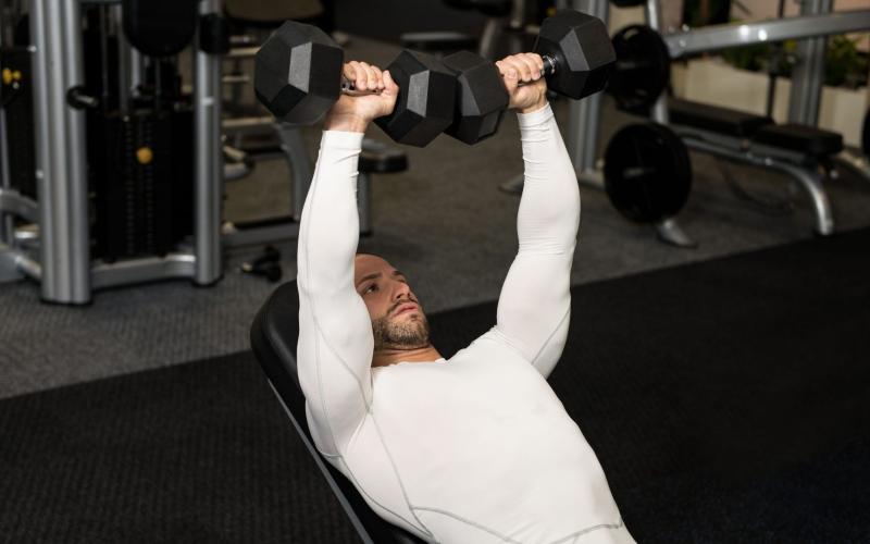 A lifter pressing dumbbells with controlled form